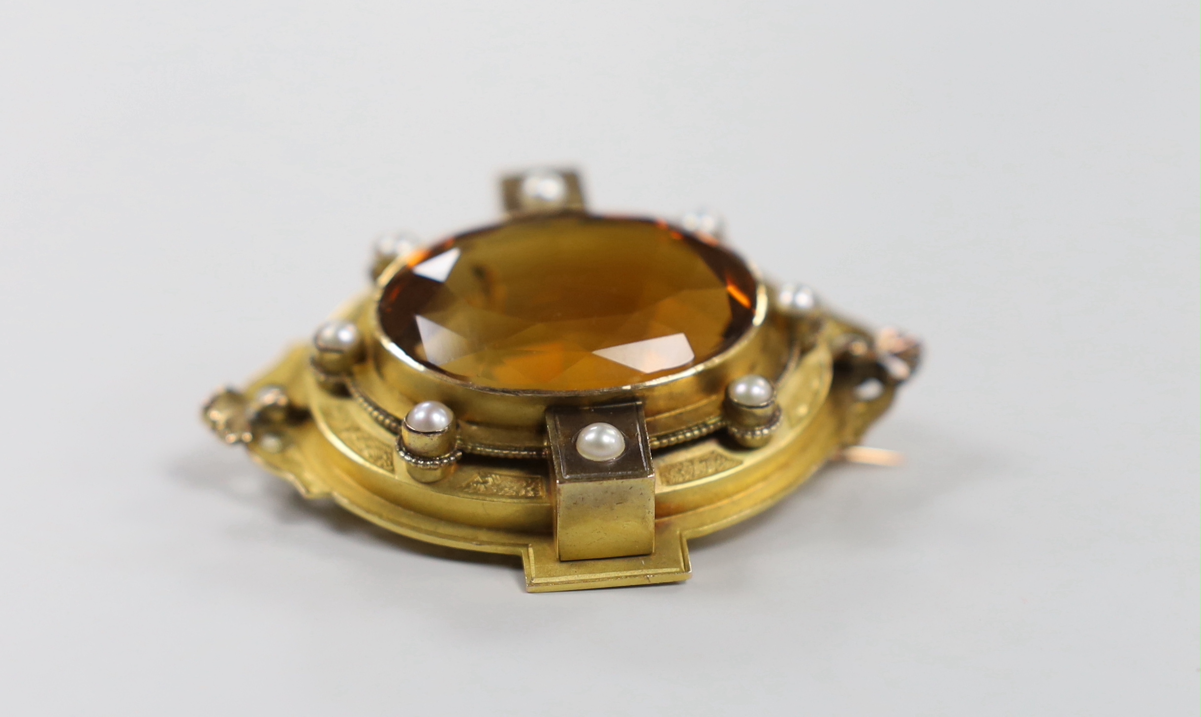 A Victorian yellow metal and large oval cut citrine set brooch, with split pearl set border, 51mm, gross weight 26.6 grams.